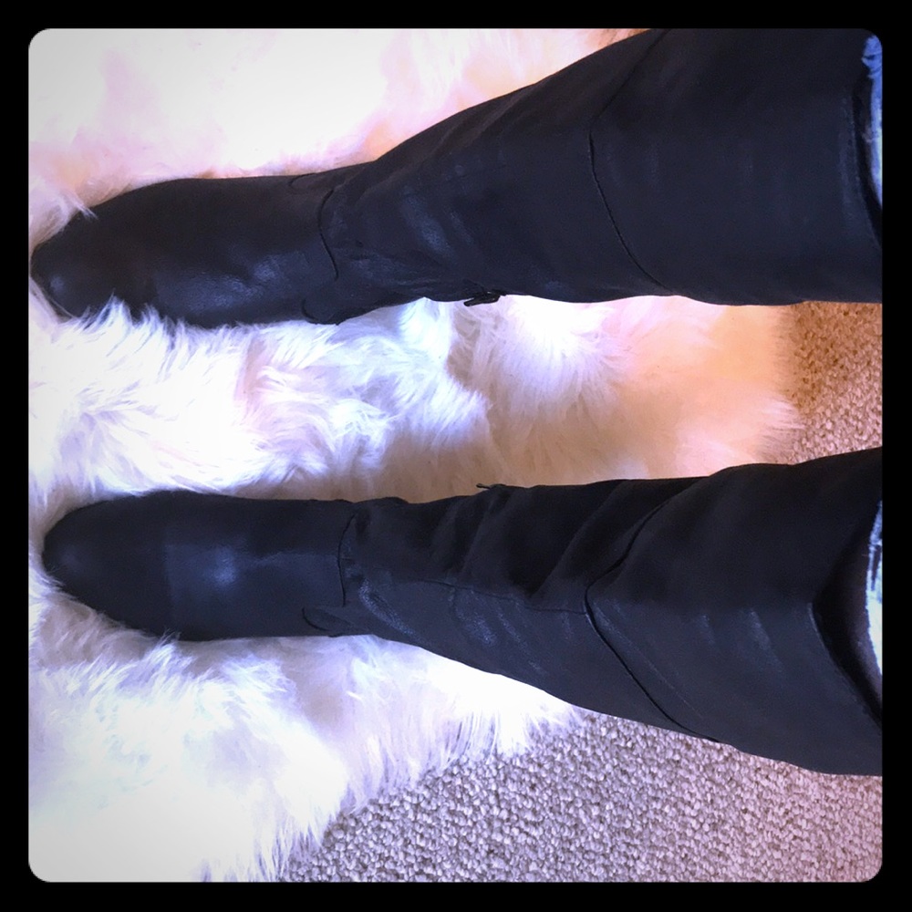 Black genuine leather knee high boots .